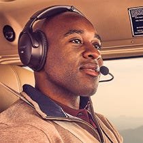 Pilot flying plane wearing aviation headset
